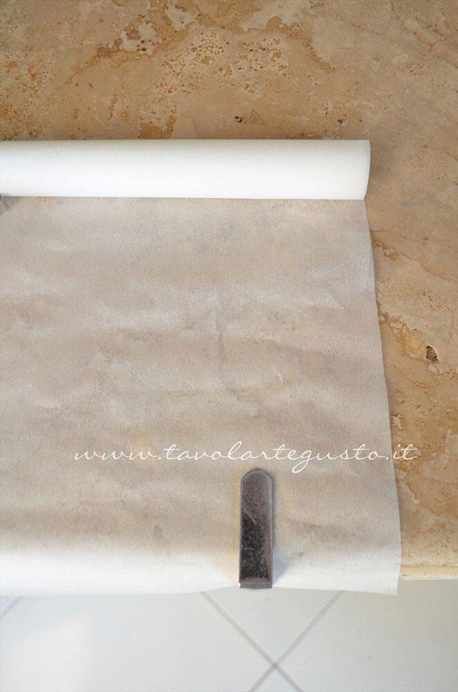 Preparare la carta da forno sul piano di lavoro - Ricetta Pasta Brisee Preparare la carta da forno sul piano di lavoro - Ricetta Pasta Brisee