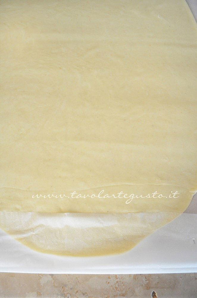 Ripiegare la carta da forno sulla sfoglia di Pasta Brisee - Ricetta Pasta Brisee Ripiegare la carta da forno sulla sfoglia di Pasta Brisee - Ricetta Pasta Brisee
