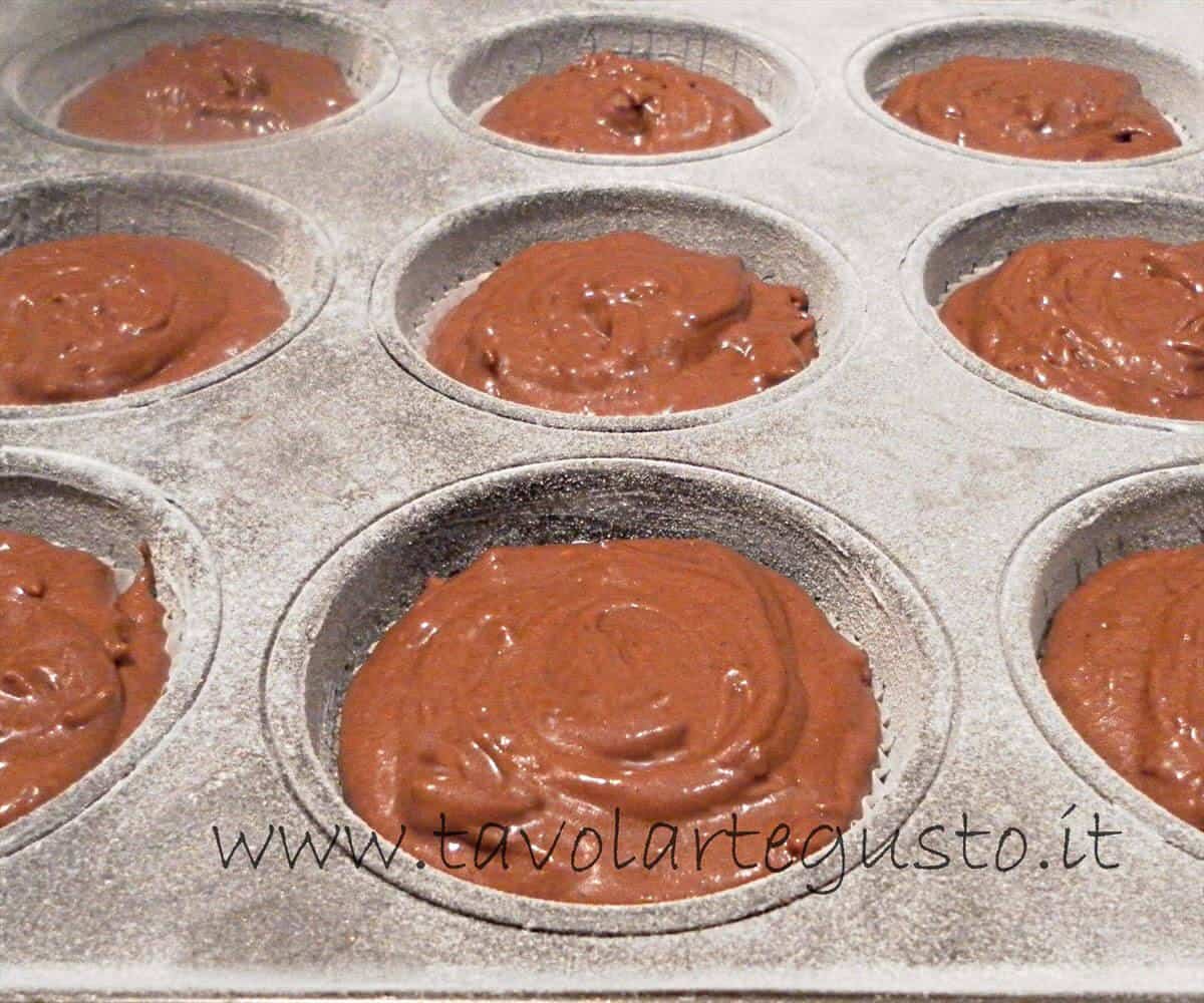 Versare l'impasto nei pirottini - Impasto per Muffin al cioccolato gianduia 1 - Ricetta Muffin al cioccolato gianduia Versare l'impasto nei pirottini - Impasto per Muffin al cioccolato gianduia 1 - Ricetta Muffin al cioccolato gianduia