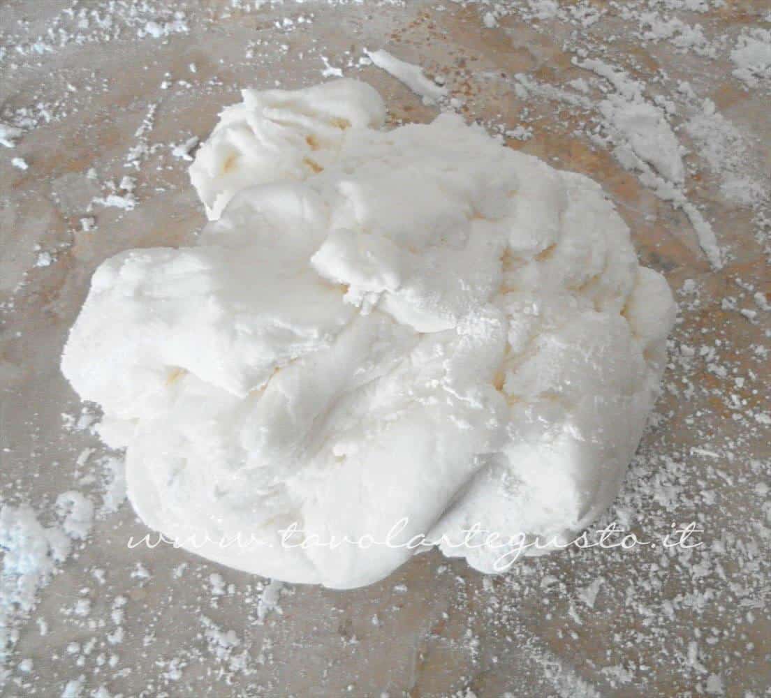 Adagiare la pasta di zucchero su una spianatoia splverata di zucchero a velo - Ricetta Pasta di Zucchero - Glassa Fondente Adagiare la pasta di zucchero su una spianatoia splverata di zucchero a velo - Ricetta Pasta di Zucchero - Glassa Fondente