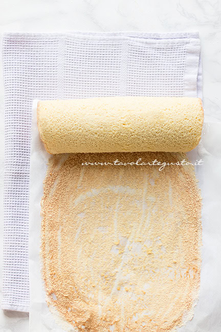 Arrotolare la pasta biscotto staccandola piano piano dalla carta da forno - Ricetta Pasta Biscotto
