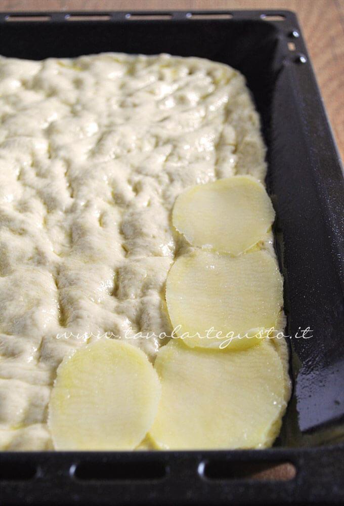 Adagiare sulla pizza le patate tagliate sottili - Ricetta Pizza con patate e rosmarino Adagiare sulla pizza le patate tagliate sottili - Ricetta Pizza con patate e rosmarino