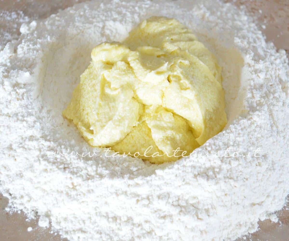 Composto montato di uova e burro nella fontana di farina - Ricetta Biscotti veloci con Philadelphia Milka Composto montato di uova e burro nella fontana di farina - Ricetta Biscotti veloci con Philadelphia Milka