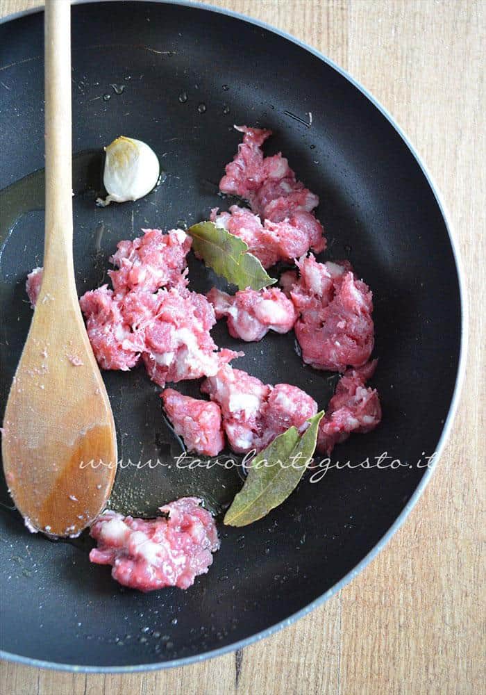 Rosolare la salsiccia con aglio e alloro - Ricetta Pasta al forno besciamella e salsiccia Rosolare la salsiccia con aglio e alloro - Ricetta Pasta al forno con besciamella