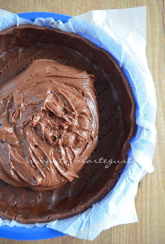Adagiare il ripieno nel guscio di frolla - Ricetta Crostata morbida al cioccolato Adagiare il ripieno nel guscio di frolla - Ricetta Crostata morbida al cioccolato