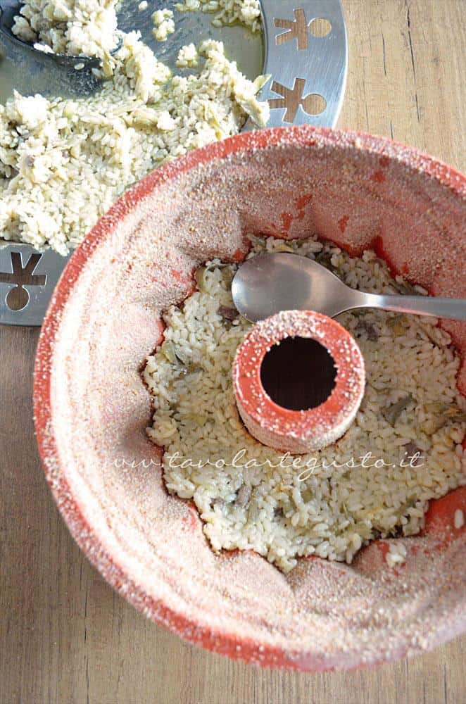 Adagiare il riso nello stampo - Ricetta Bordura di riso con crema di carciofi e crostini di Fiore Sardo Adagiare il riso nello stampo - Ricetta Bordura di riso con crema di carciofi e crostini di Fiore Sardo