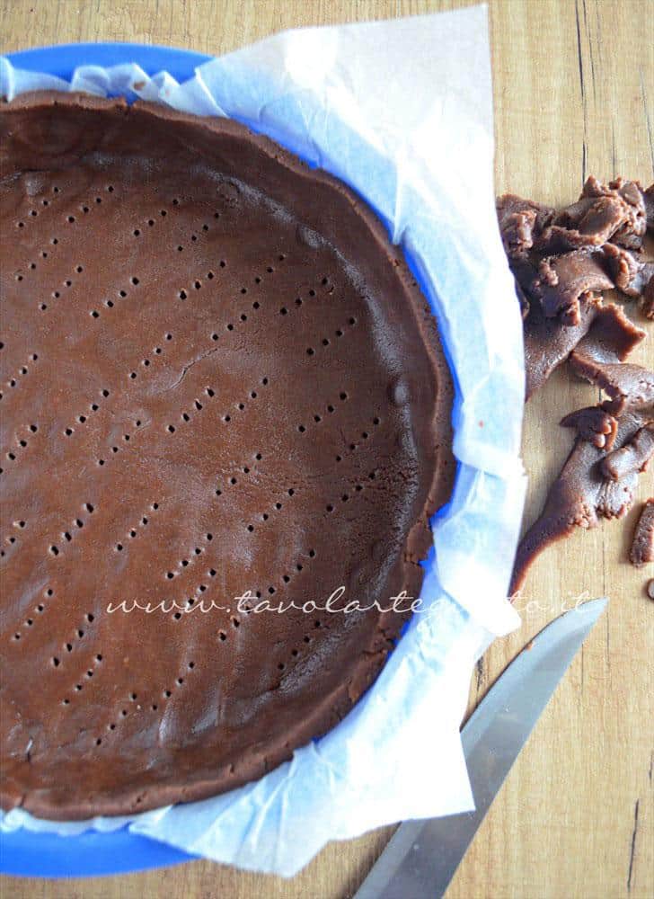 Adagiare la sfoglia di pasta frolla al cacao nello stampo - Ricetta Crostata morbida al cioccolato Adagiare la sfoglia di pasta frolla al cacao nello stampo - Ricetta Crostata morbida al cioccolato