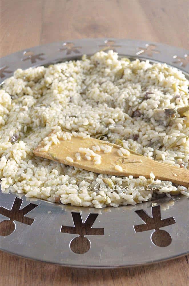 Raffreddare il riso su un vassoio - Ricetta Bordura di riso con crema di carciofi e crostini di Fiore Sardo Raffreddare il riso su un vassoio - Ricetta Bordura di riso con crema di carciofi e crostini di Fiore Sardo