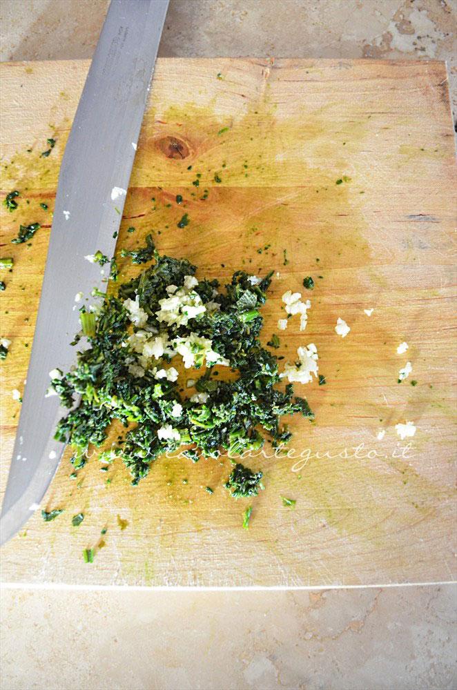 Tritare finemente gli aromi e l'aglio - Ricetta Filetto di salmone al cartoccio Tritare finemente gli aromi e l'aglio - Ricetta Filetto di salmone al cartoccio