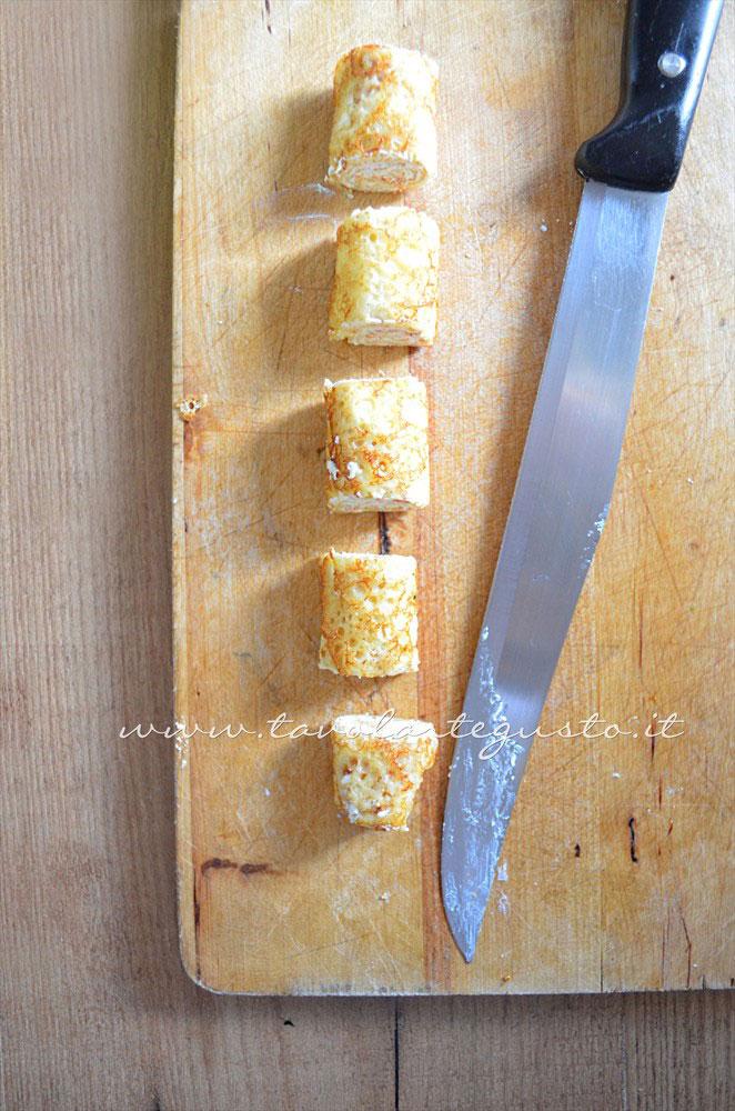 Affettare il rotolo di crepe - Ricetta Rotolini di Crepes alla ricotta Affettare il rotolo di crepe - Ricetta Rotolini di Crepes alla ricotta