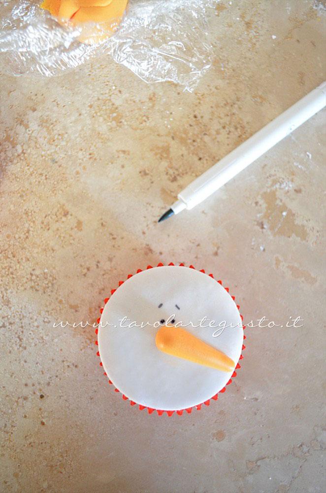 Disegnare occhi e sopraciglia al pupazzo di neve - Ricetta Cupcakes Natalizi decorati in Pasta di Zucchero - Cupcakes di Natale Disegnare occhi e sopraciglia al pupazzo di neve - Ricetta Cupcakes Natalizi decorati in Pasta di Zucchero - Cupcakes di Natale