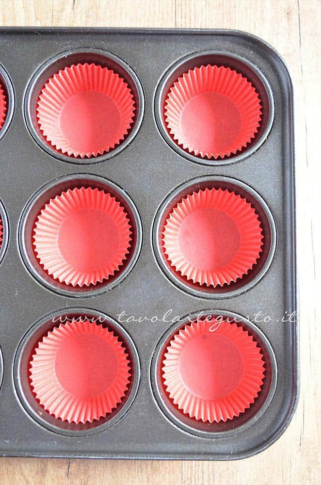 Inserire i pirottini nello stampo - Ricetta Cupcakes Natalizi decorati in Pasta di Zucchero - Cupcakes di Natale Inserire i pirottini nello stampo - Ricetta Cupcakes Natalizi decorati in Pasta di Zucchero - Cupcakes di Natale