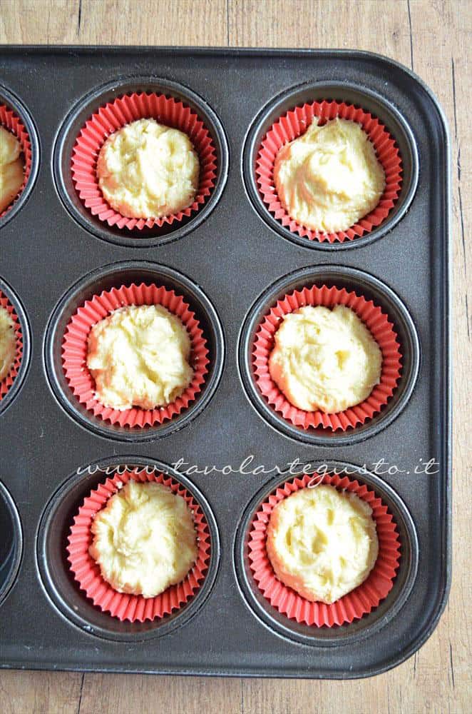 Inserire l'impasto nei pirottini - Ricetta Cupcakes Natalizi decorati in Pasta di Zucchero - Cupcakes di Natale Inserire l'impasto nei pirottini - Ricetta Cupcakes Natalizi decorati in Pasta di Zucchero - Cupcakes di Natale
