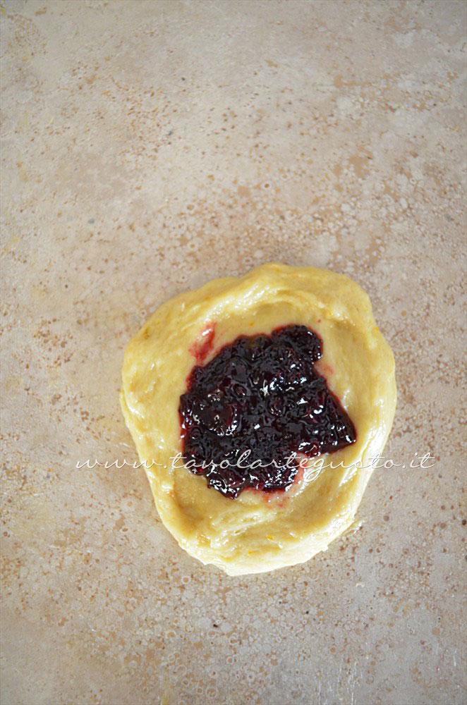 Stendere la pallina e adagiare il ripieno - Ricetta Brioches ripiene Stendere la pallina e adagiare il ripieno - Ricetta Brioches ripiene