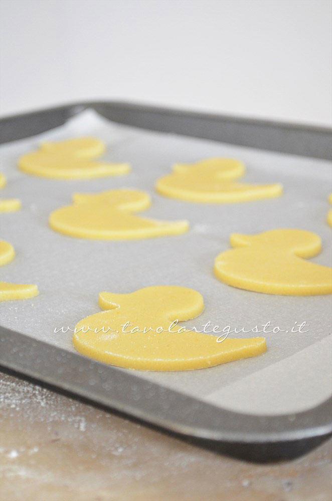 Adagiare i biscotti in una teglia - Ricetta Biscotti di Pasqua Pulcini decorati in Pasta di Zucchero Adagiare i biscotti in una teglia - Ricetta Biscotti di Pasqua Pulcini decorati in Pasta di Zucchero