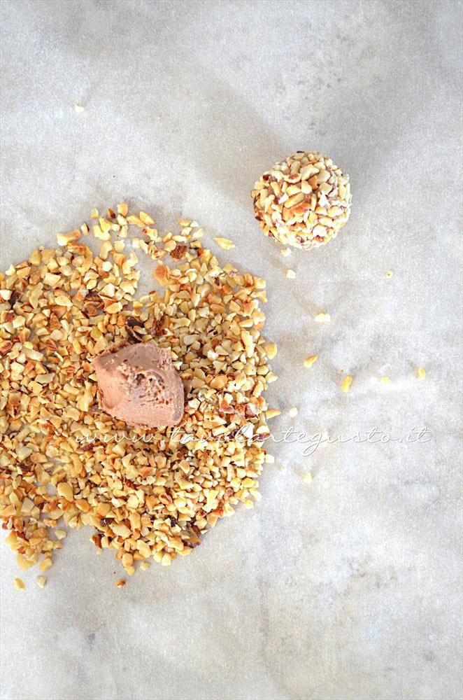 Ricoprire i Tartufi di granella di nocciole - Ricetta Tartufi al cioccolato al latte e nocciole Ricoprire i Tartufi di granella di nocciole - Ricetta Tartufi al cioccolato al latte e nocciole