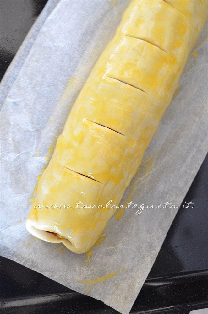 Pennellare con tuorlo e incidere dei tagli - Ricetta Strudel di verdure Pennellare con tuorlo e incidere dei tagli - Ricetta Strudel di verdure