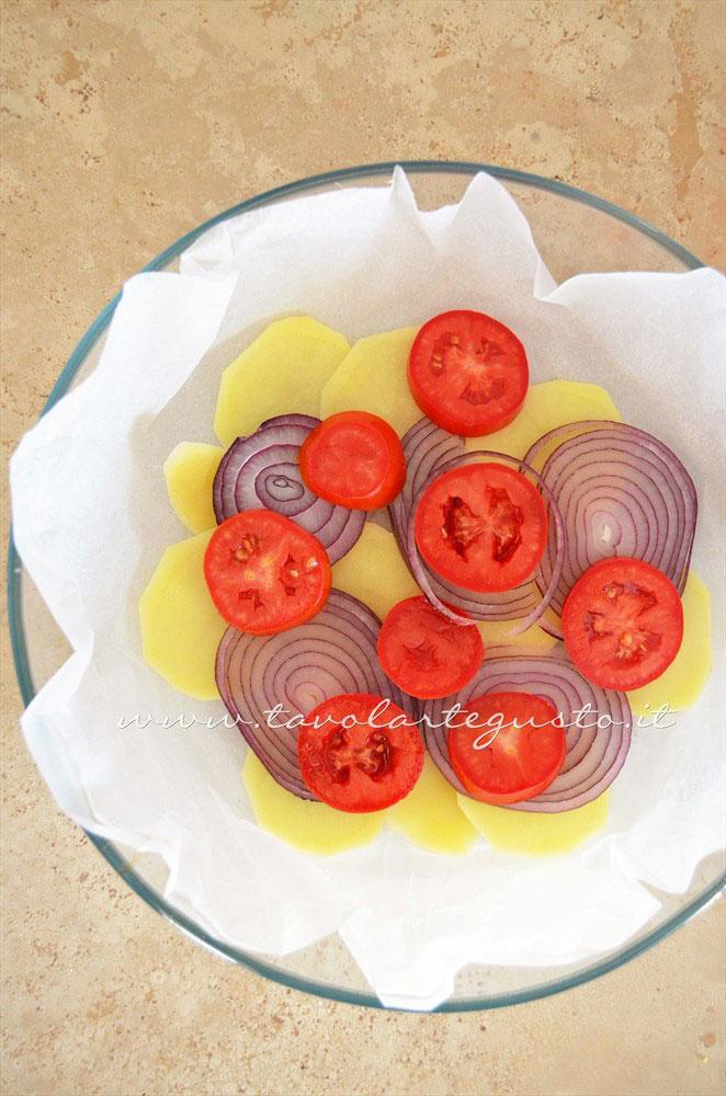 Disporre in tortiera il primo strato di verdure -Ricetta Patate e cipolle al forno con pomodori e pecorino Disporre in tortiera il primo strato di verdure -Ricetta Patate e cipolle al forno con pomodori e pecorino