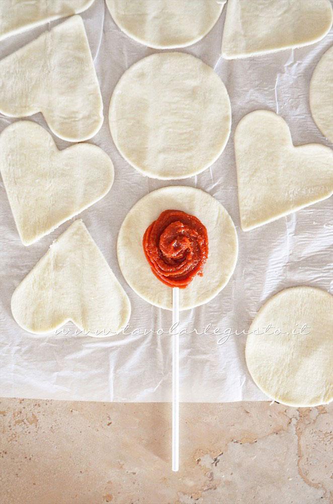 Inserire lo stecco sulla sfoglia farcita - Ricetta Lecca lecca salati di pasta sfoglia Inserire lo stecco sulla sfoglia farcita - Ricetta Lecca lecca salati di pasta sfoglia