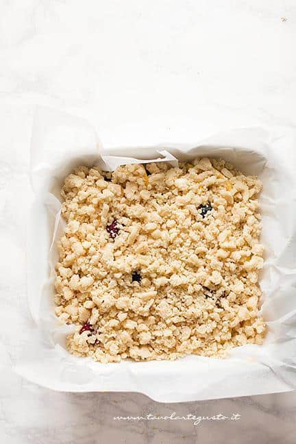 Riempire la superficie della torta con il crumble - Ricetta Torta Crumble alla frutta (pesche e mirtilli)