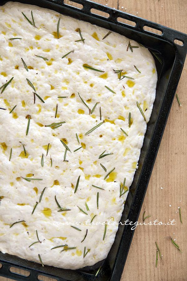 Focaccia condita e pronta per essere infornata - Ricetta Focaccia veloce e senza impasto Focaccia condita e pronta per essere infornata - Ricetta Focaccia veloce e senza impasto