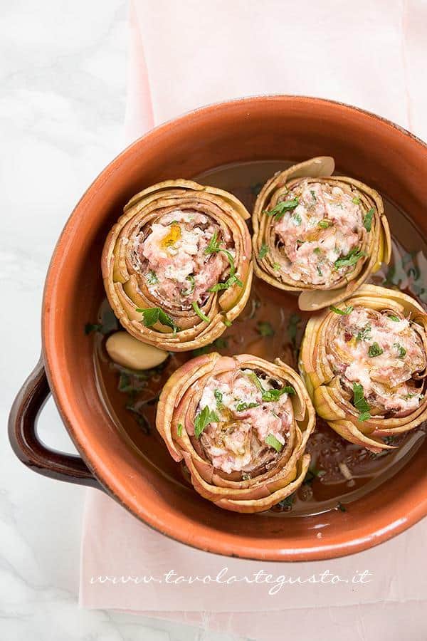 Riempire i Carciofi con la farcia e sistemarli nel coccio - Ricetta Carciofi ripieni Riempire i Carciofi con la farcia e sistemarli nel coccio - Ricetta Carciofi ripieni di salsiccia