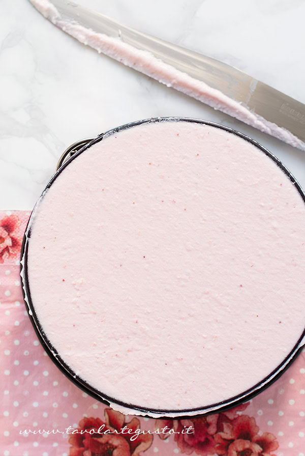 Versare il composto alle fragole sulla base di Cheesecake e livellare con un coltello lungo - Ricetta Cheesecake alle