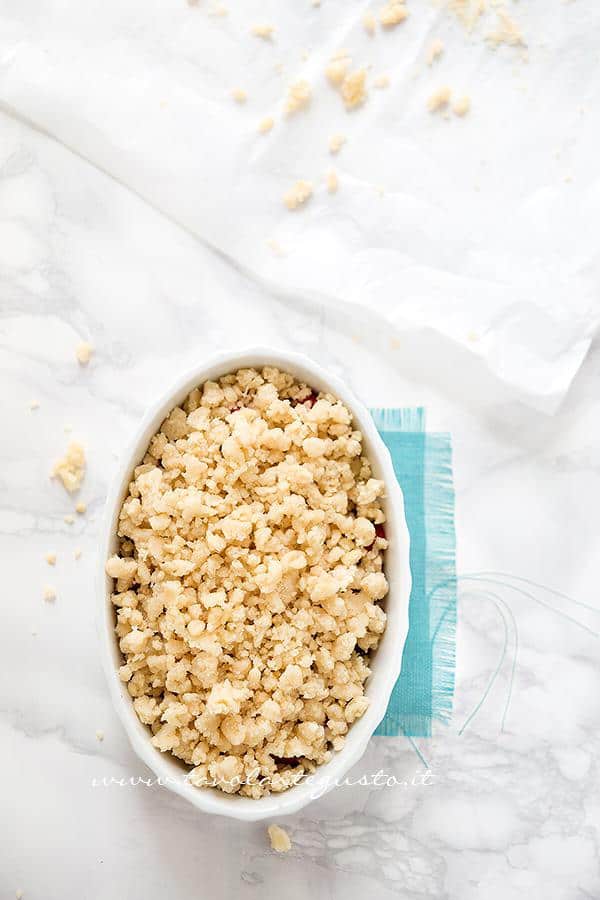 ricoprire di briciole il ripieno per crumble di fragole