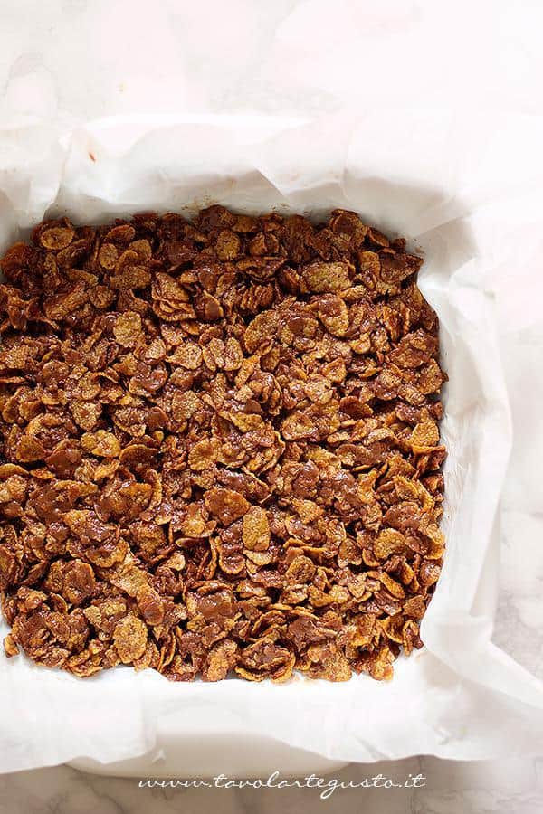 Disporre il composto in teglia - Ricetta Barrette di cioccolato e corn flakes