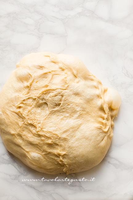 Rovesciare su un piano di lavoro l'impasto lievitato -Ricetta Pandorini