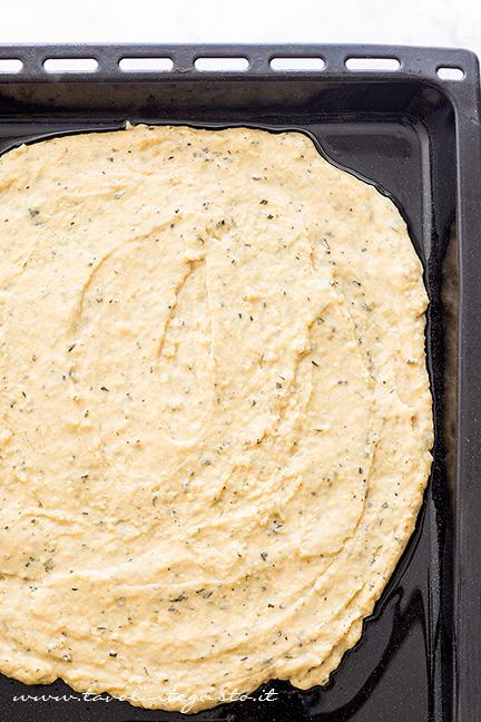 Stendere l'impasto in una teglia unta - Ricetta Chips di farina di ceci e rosmarino