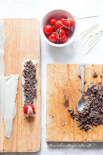 Aggiungere un pomodorino sulla coda del filetto e arrotolare la platessa - Ricetta Involtini di Platessa