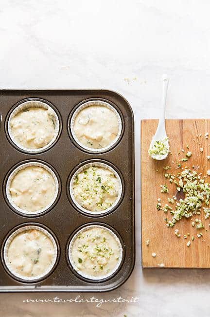 Inserire l'impasto nei pirottini -Muffin alle zucchine