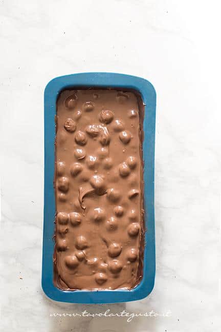 Versare nel guscio di cioccolato il mix di cioccolati e nocciole - Ricetta Torrone dei morti