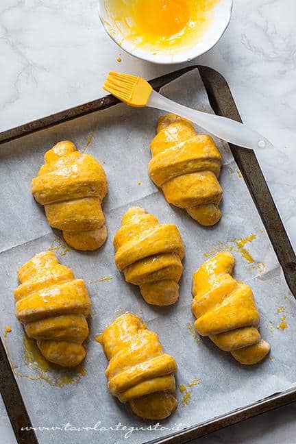 Pennellare con un uovo i cornetti lievitati - Ricetta Cornetti Integrali al miele