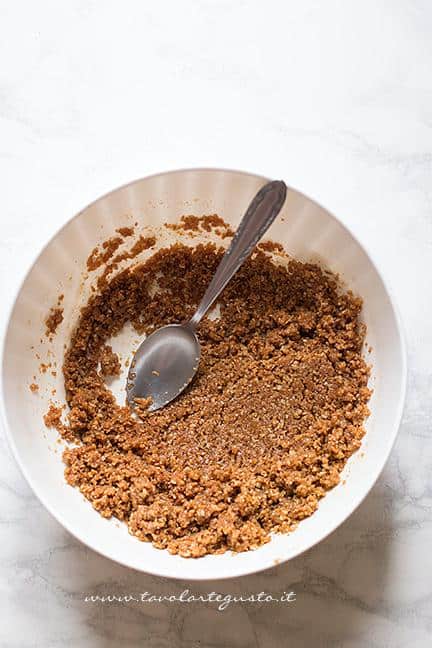 Mescolare i biscotti sbriciolati con il burro e il miele - Ricetta Crostata senza cottura