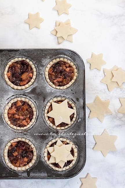 Chiudere la superficie dei mince pie con biscottini a forma di stella in superficie - Ricetta Mince Pies