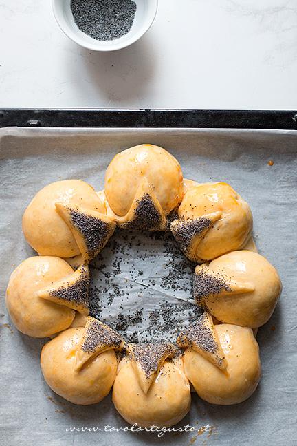 Ricoprire gli spicchi con semi di papavero - Ricetta Corona Salata di pan brioche
