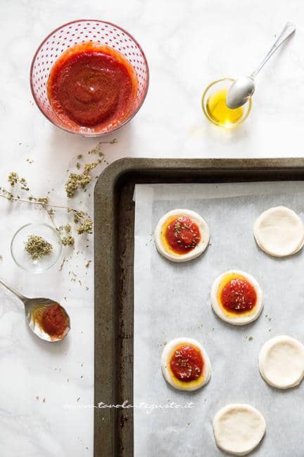 Condire le pizzette con la salsa di pomodoro - Ricetta Pizzette allo yogurt