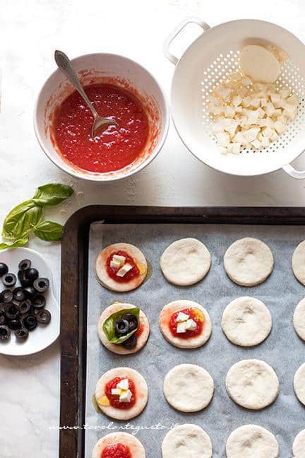 Condire le pizzette con sugo, mozzarella oppure olive - Ricetta Pizzette allo yogurt