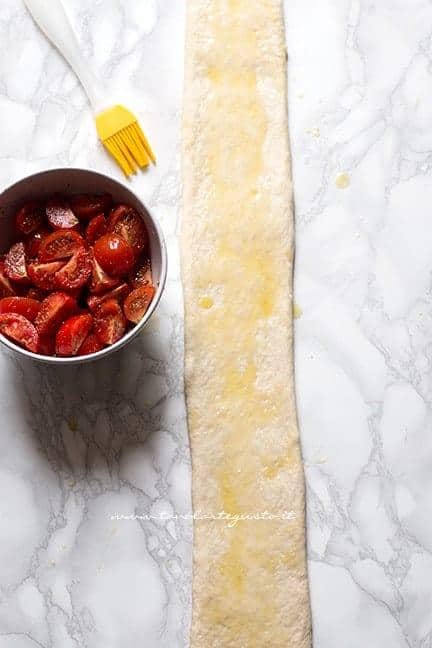 Stendere con un mattarello l'impasto a pennellare con olio - Ricetta Focaccia arrotolata