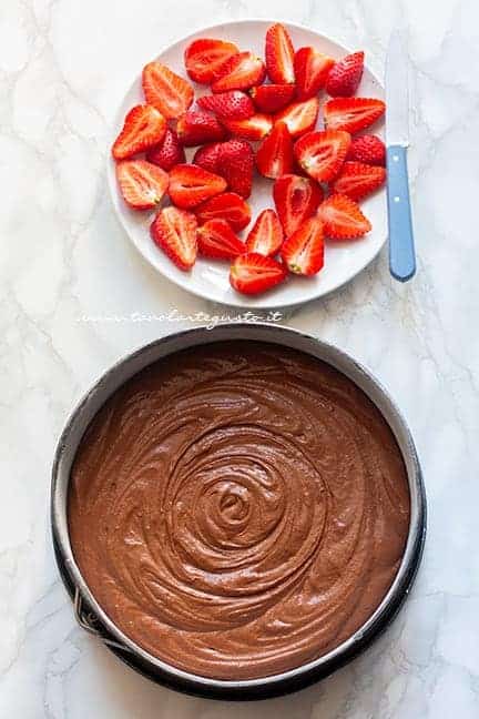 versare l'impasto in teglia e tagliare le fragole - Ricetta Torta cioccolato e fragole