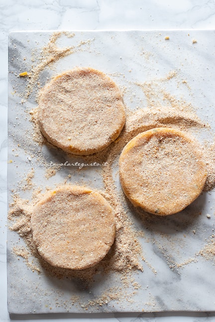 ricoprire gli hamburger di zucca di pan grattato