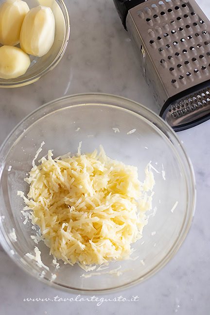 grattugiare le patate per fare la schiacciata di patate